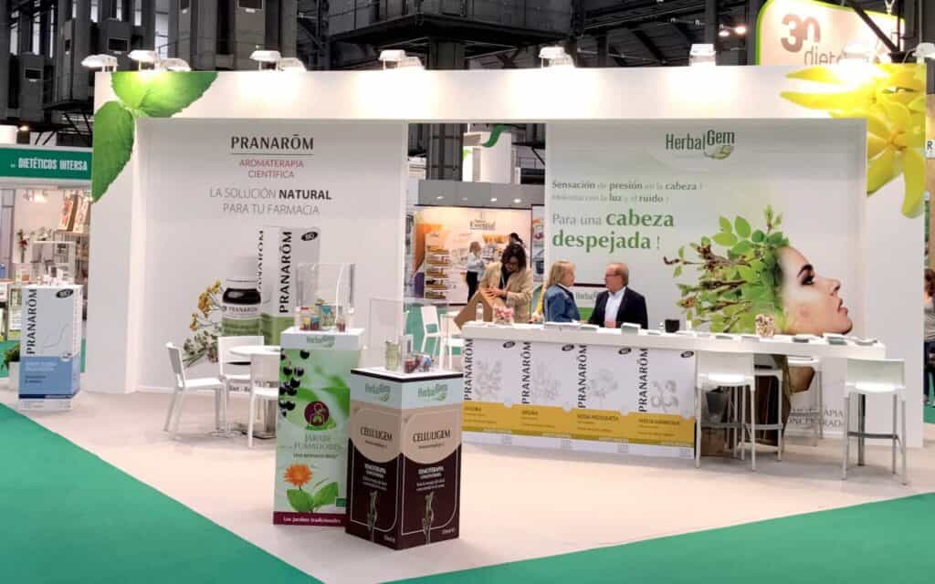 Stand de Pranarôm en una feria, con mostrador, gráfica de marca y producto expuesto