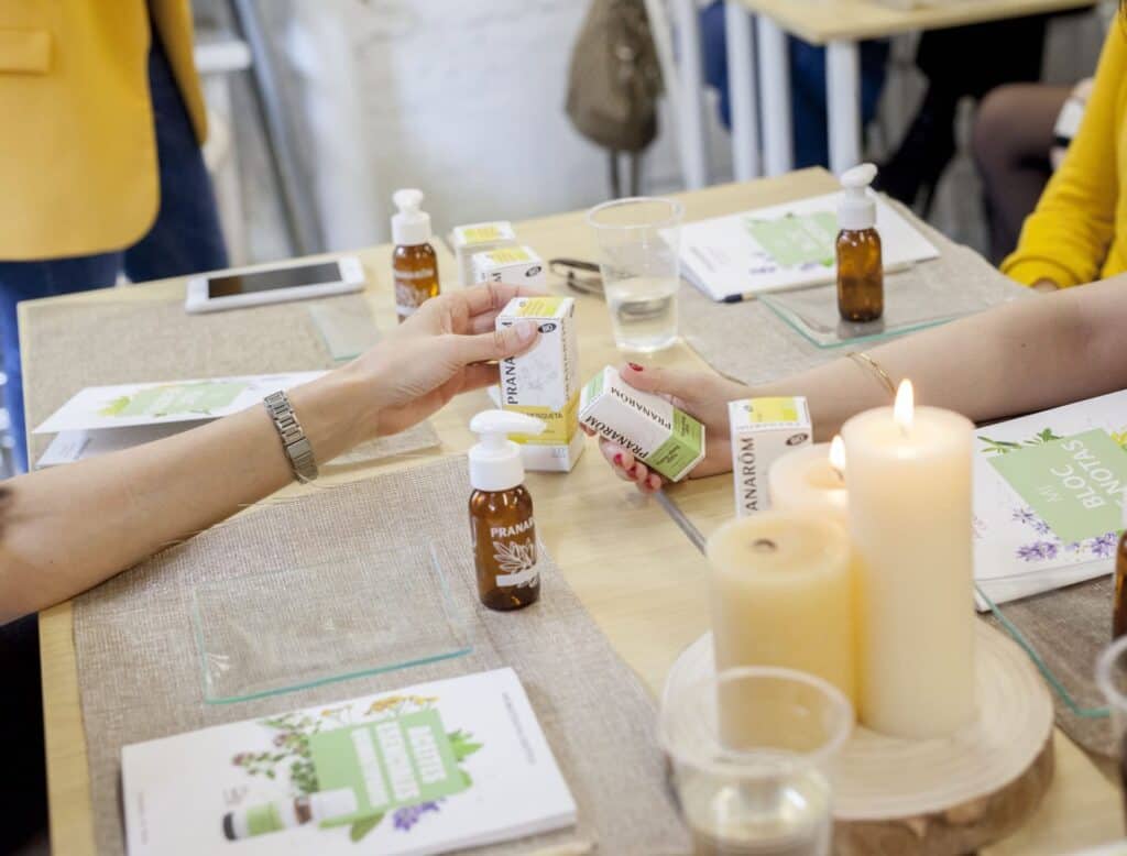 Mesa con aceites esenciales de Pranarôm, velas y material impreso de la marca