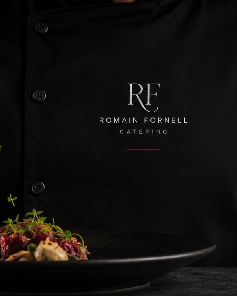 The RF monogram of Romain Fornell Catering on black fabric, next to one of the house dishes