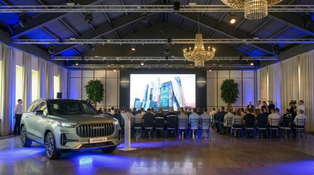 Sala de presentación con el vehículo en primer plano, la pantalla y el público sentado. Visualización creada con IA.