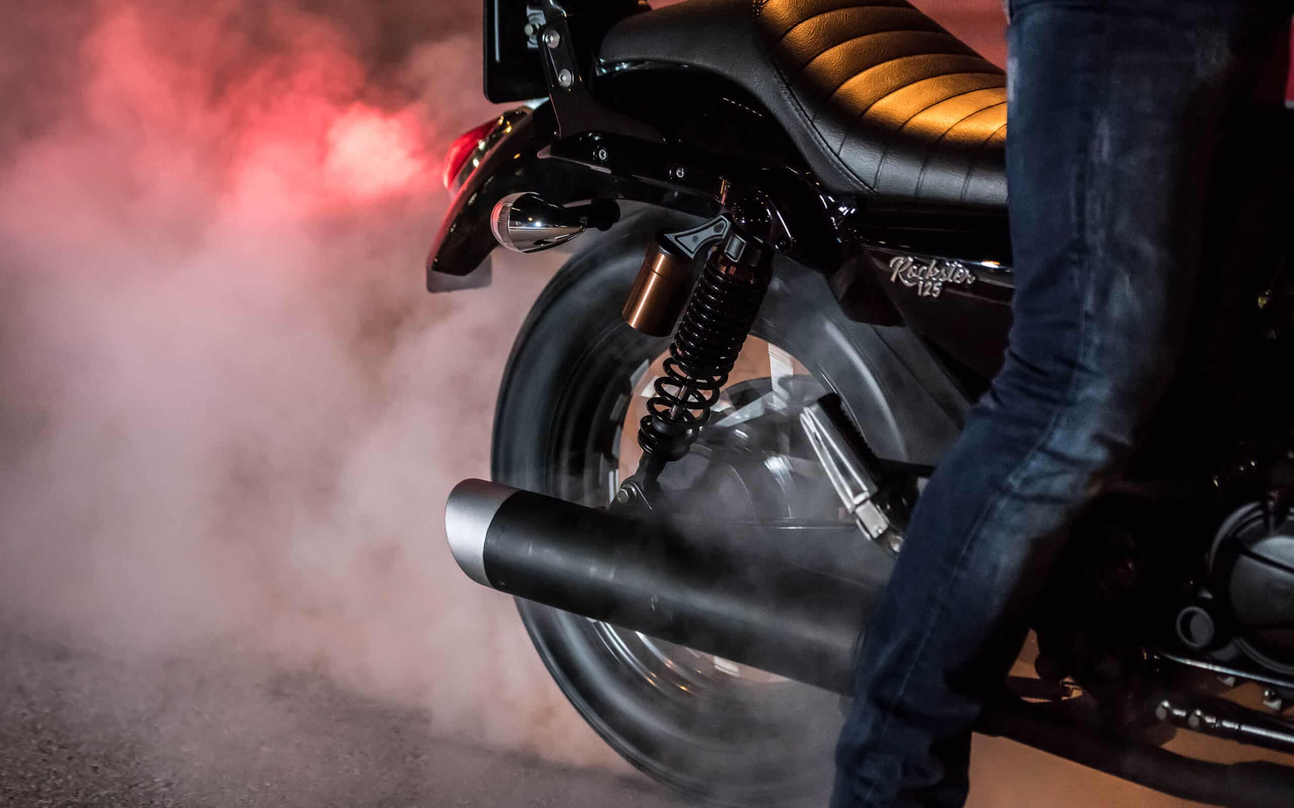 Una Macbor quemando rueda entre humo rojo