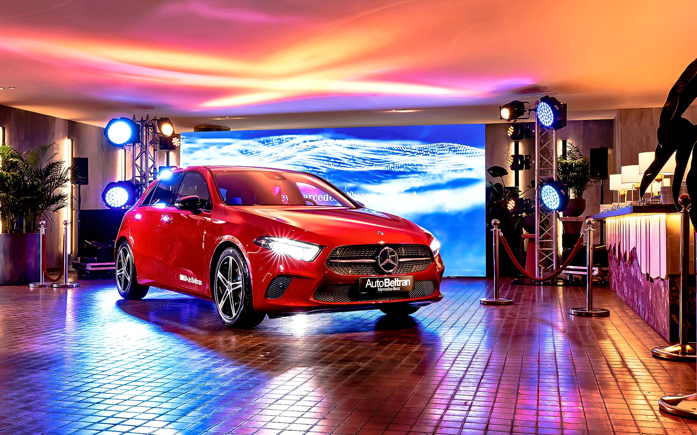 El nuevo Clase A rojo sobre el escenario del Hotel Sofia, con pantalla de fondo y focos