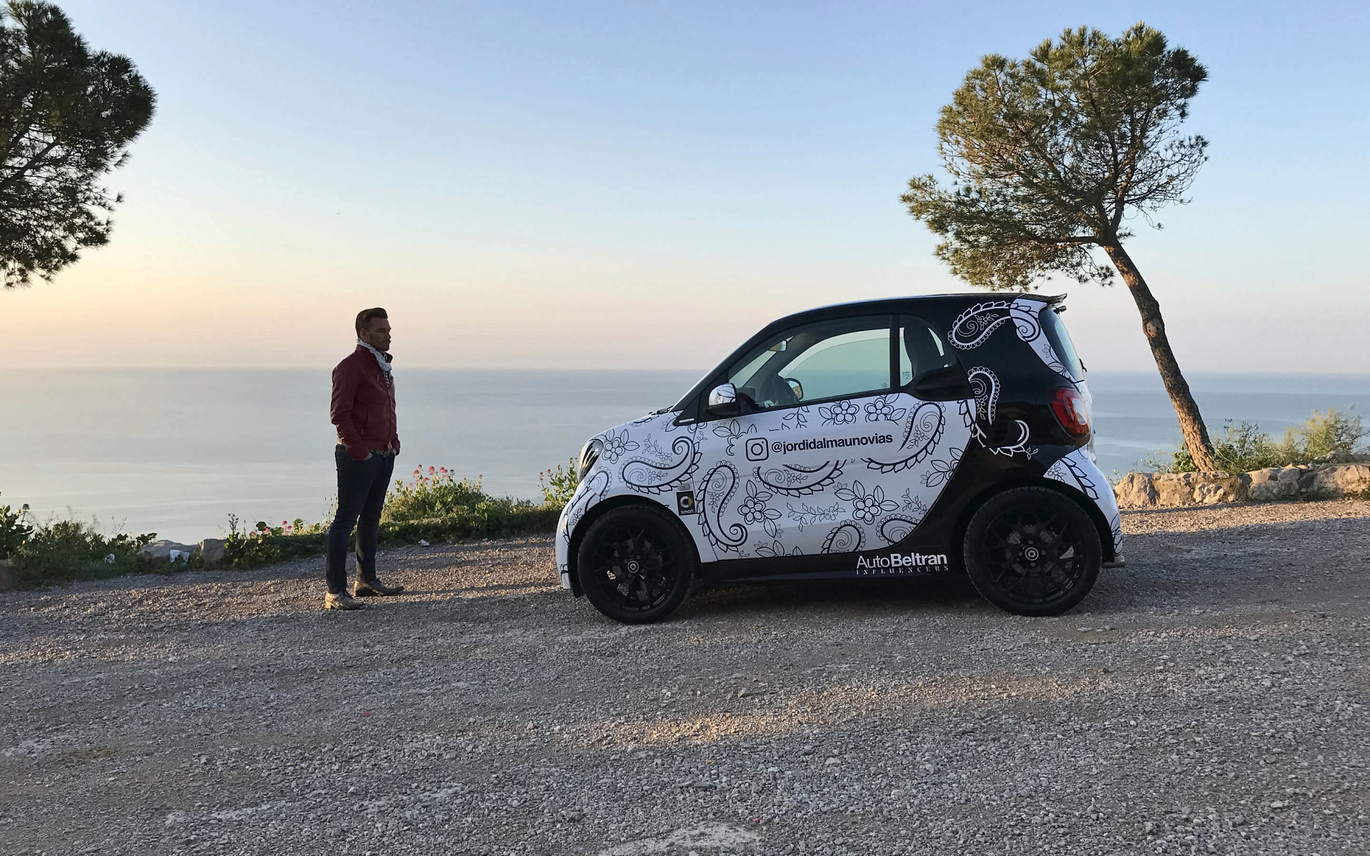 El smart vestido de encaje en un mirador sobre el mar al atardecer