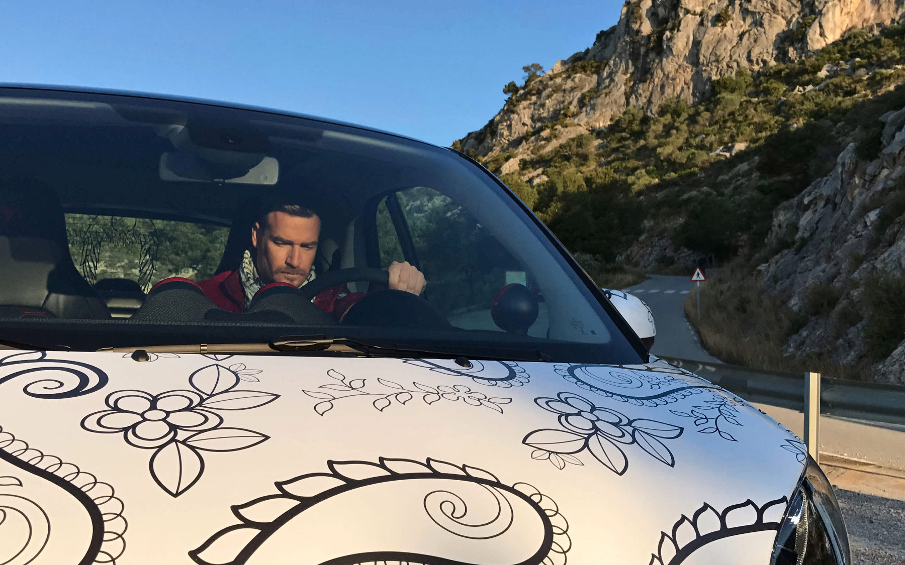 Al volante del smart con el capó dibujado con encaje