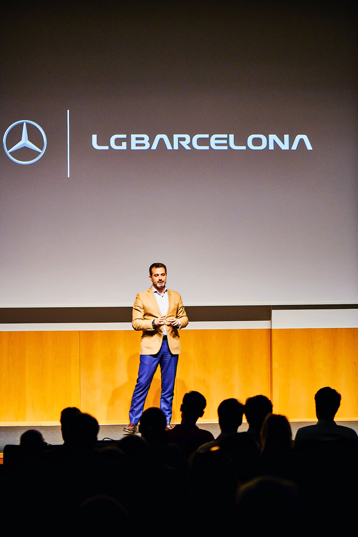 Escenario con el logotipo de LG Barcelona en pantalla y el público en sombra
