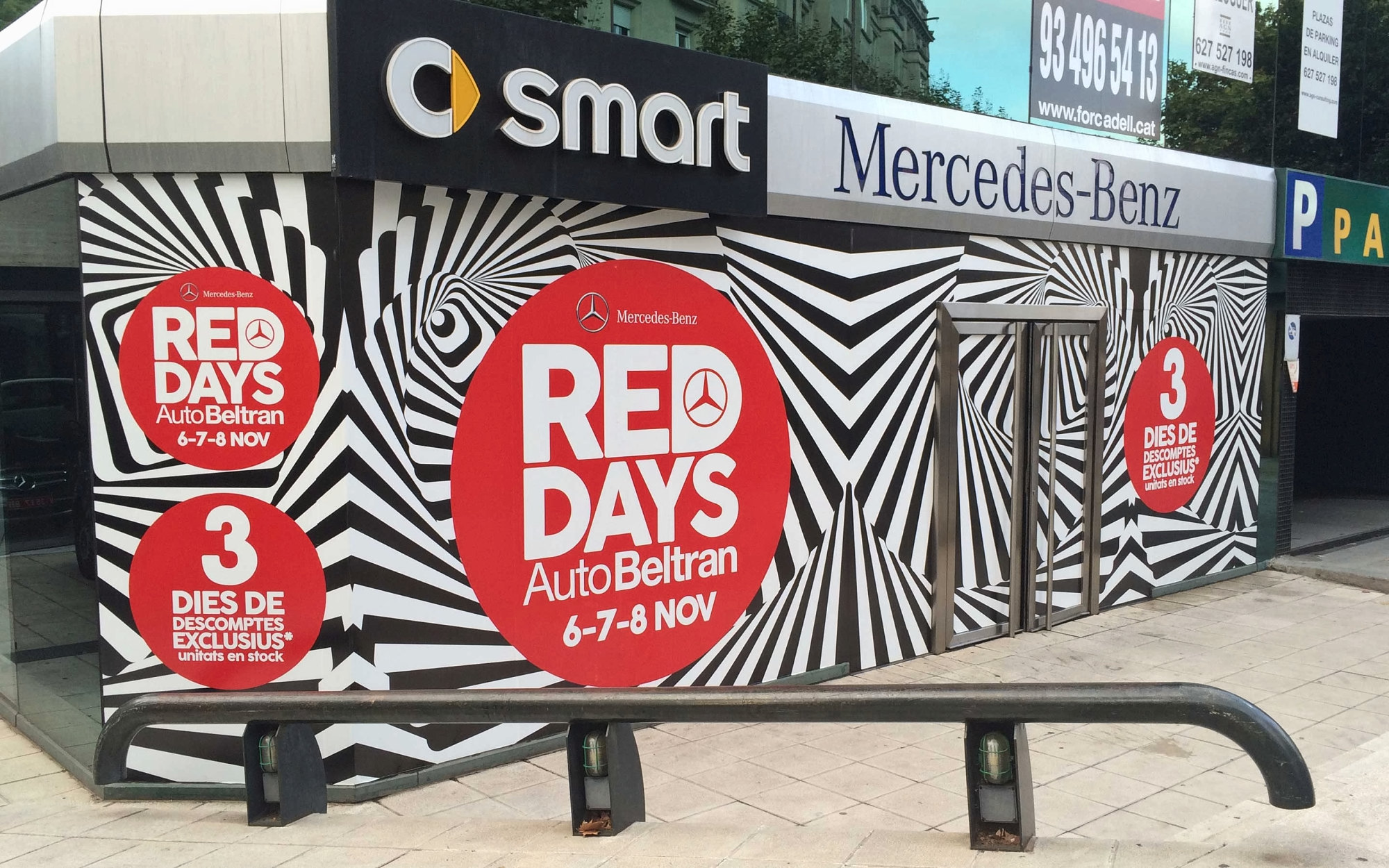 Fachada del concesionario vestida con la campaña Red Days: rayas en blanco y negro y círculos rojos