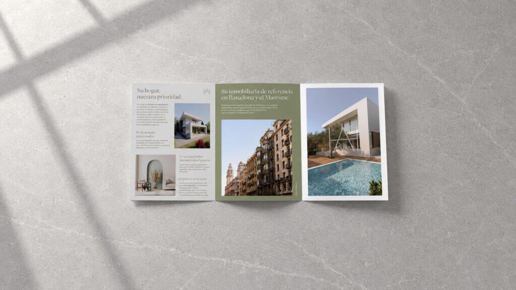 Recreación: folleto de Access Home abierto sobre una superficie de piedra, con la presentación de la inmobiliaria en Barcelona y el Maresme