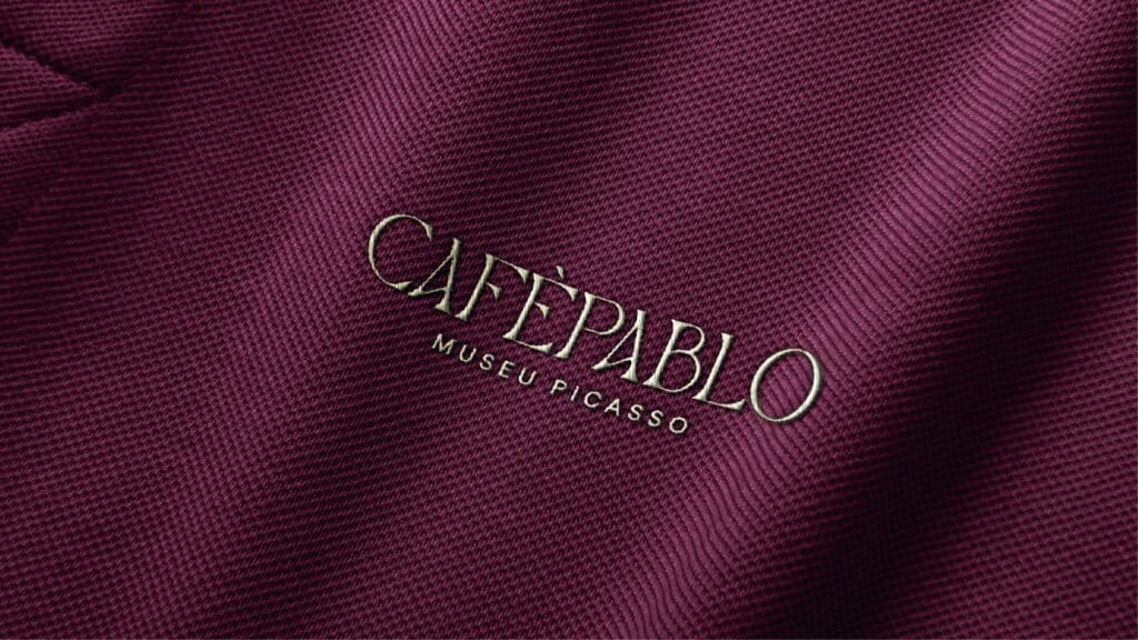 Logotipo de Café Pablo bordado sobre tejido granate