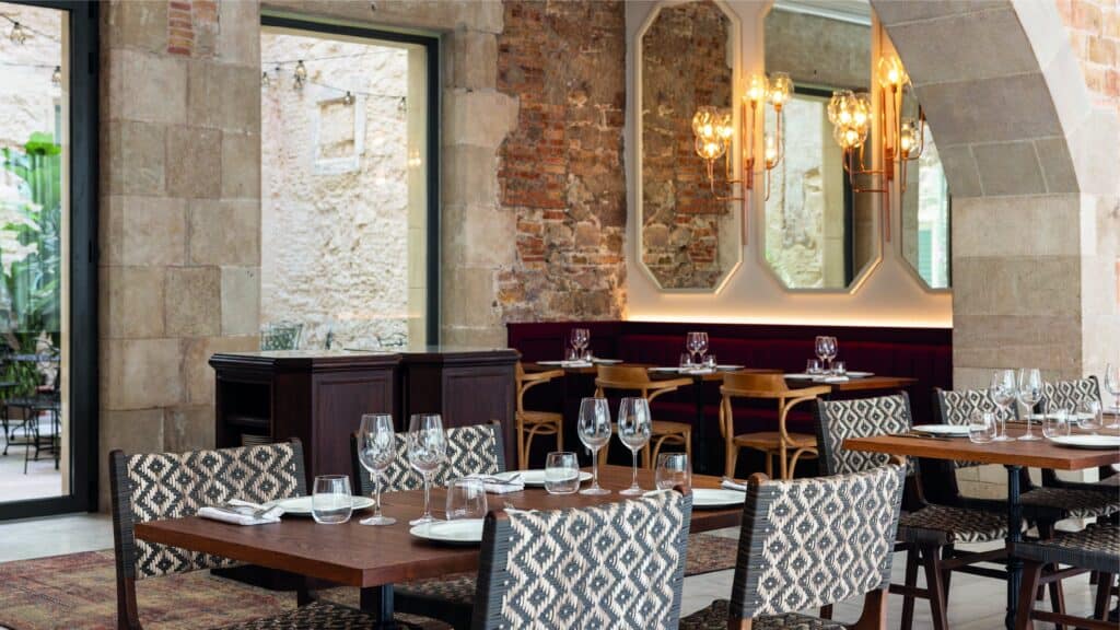 Comedor de Café Pablo con arcos de piedra, espejos y sillas tapizadas