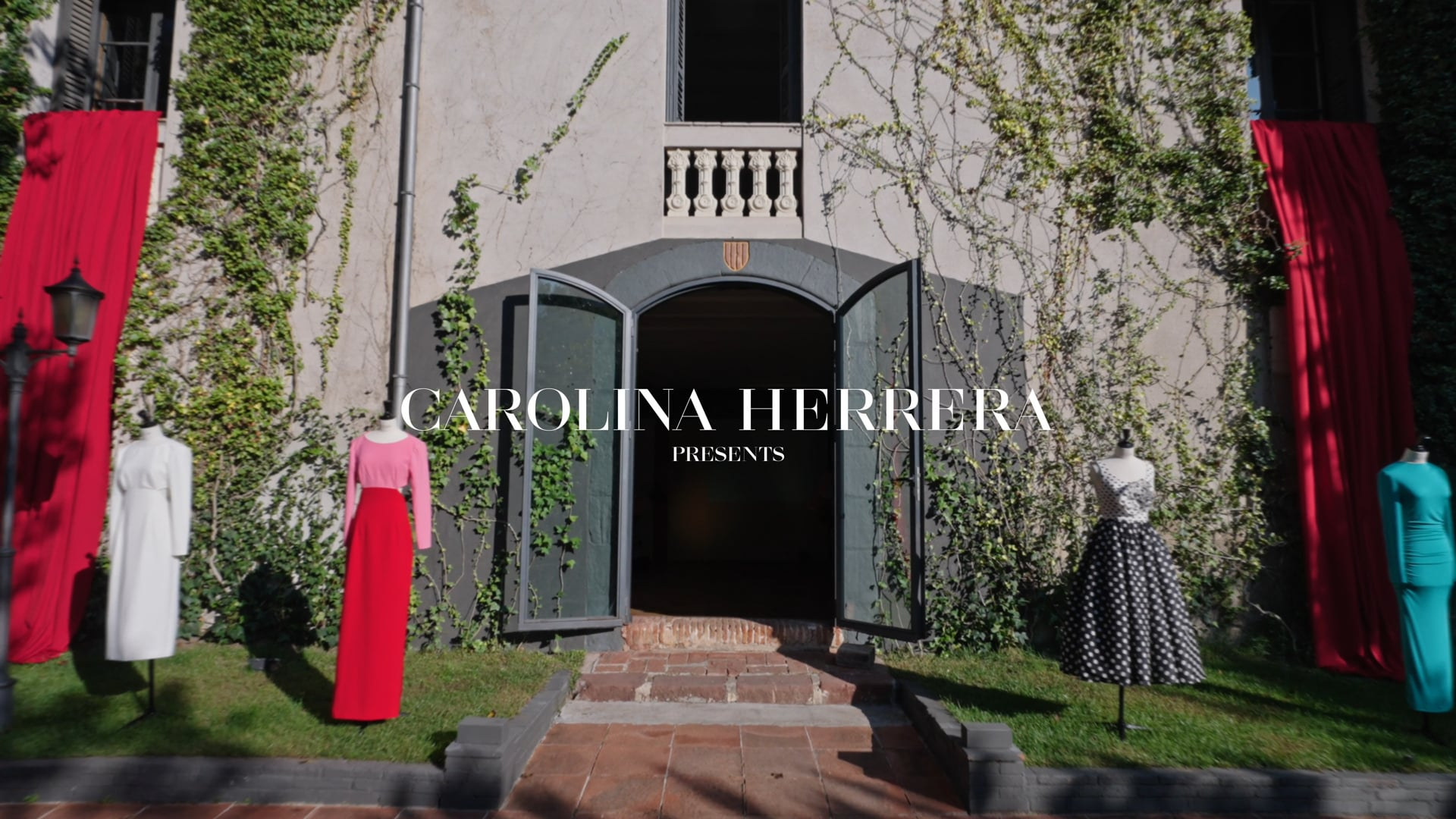 La fachada de Mas Vidrier vestida de rojo, con vestidos de Carolina Herrera en el jardín y el título de la película: Carolina Herrera presents