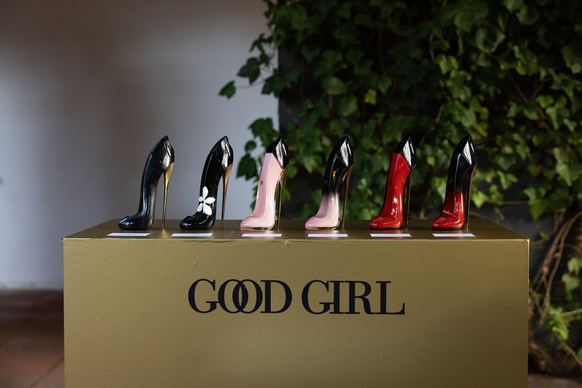 El podio dorado de Good Girl con la fila de frascos en forma de stiletto