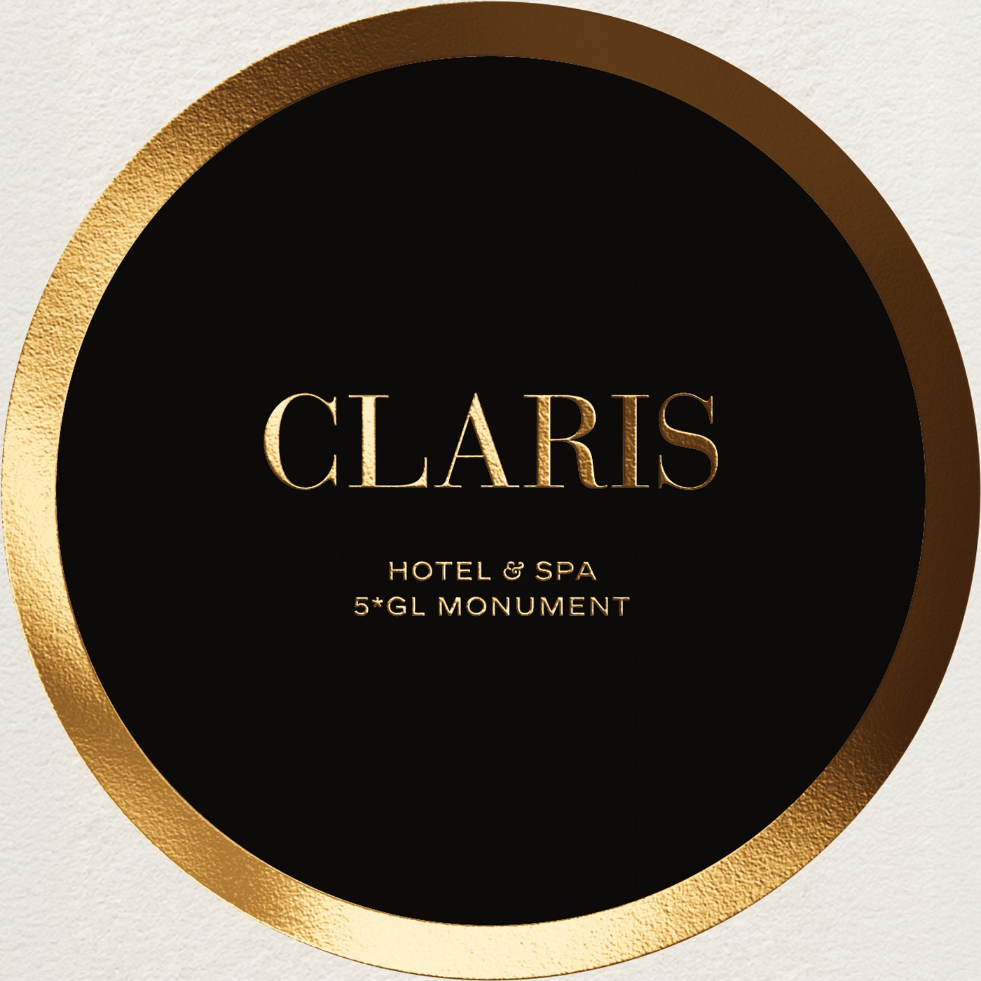 Recreación: el círculo de la invitación de La Terraza del Claris 2026, con el logotipo del Claris y el anillo en stamping oro sobre negro