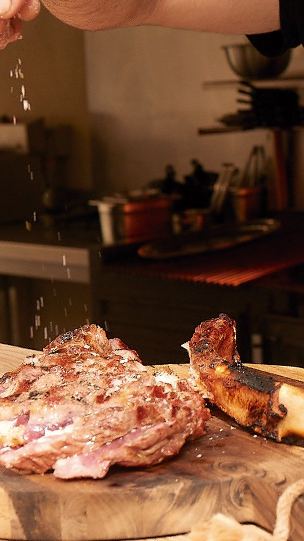 Carne a la brasa sobre la tabla en Mamut