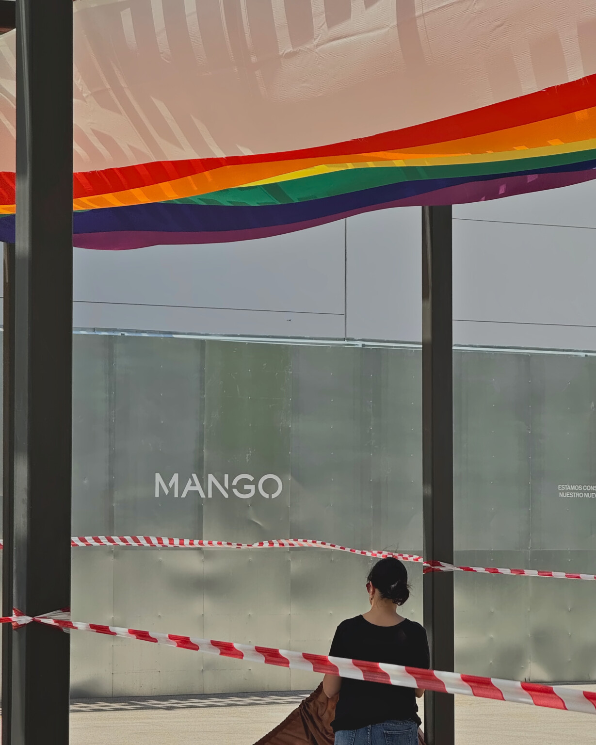 Montaje de las telas del Orgullo junto al rótulo de Mango, con la zona balizada