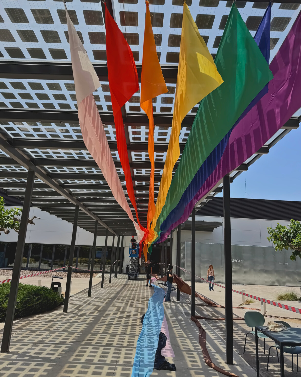Once telas del Orgullo en perspectiva bajo la pérgola de la sede central de Mango