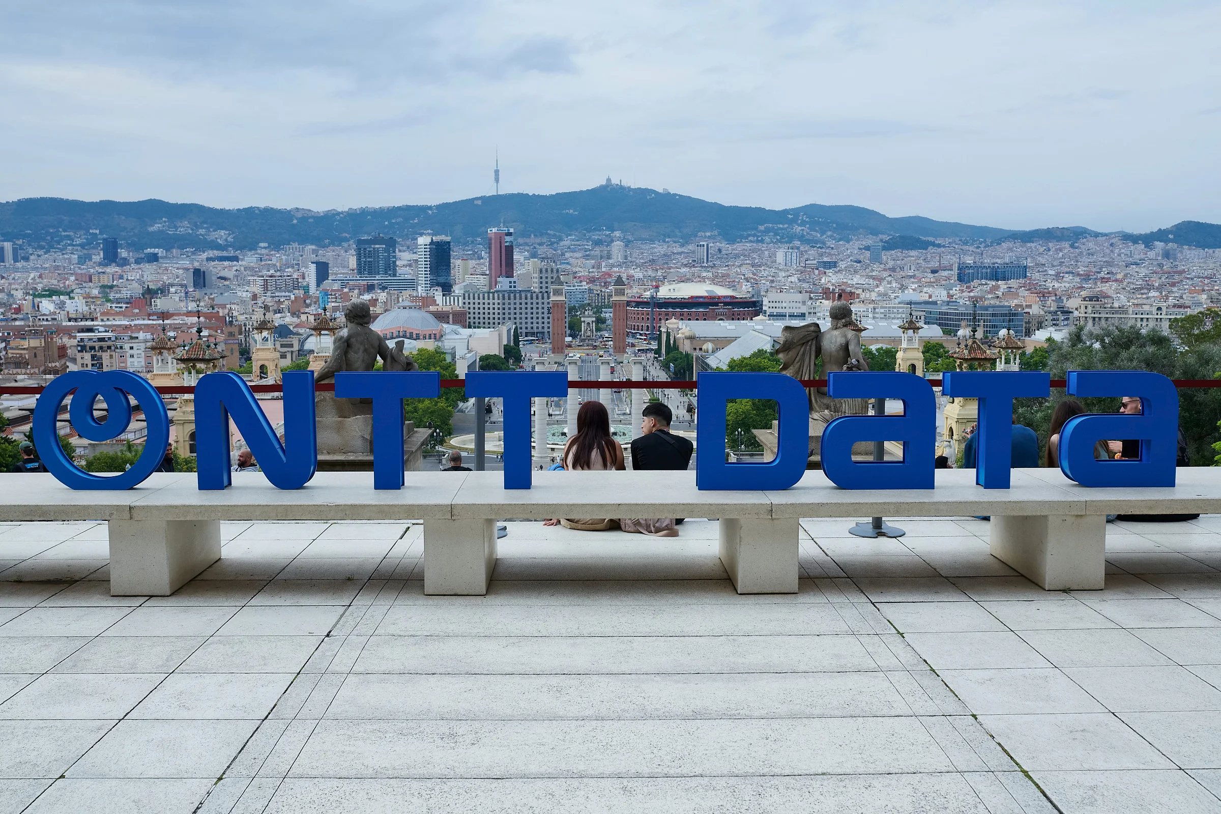 Letras de NTT DATA en la terraza del MNAC, con Barcelona detrás