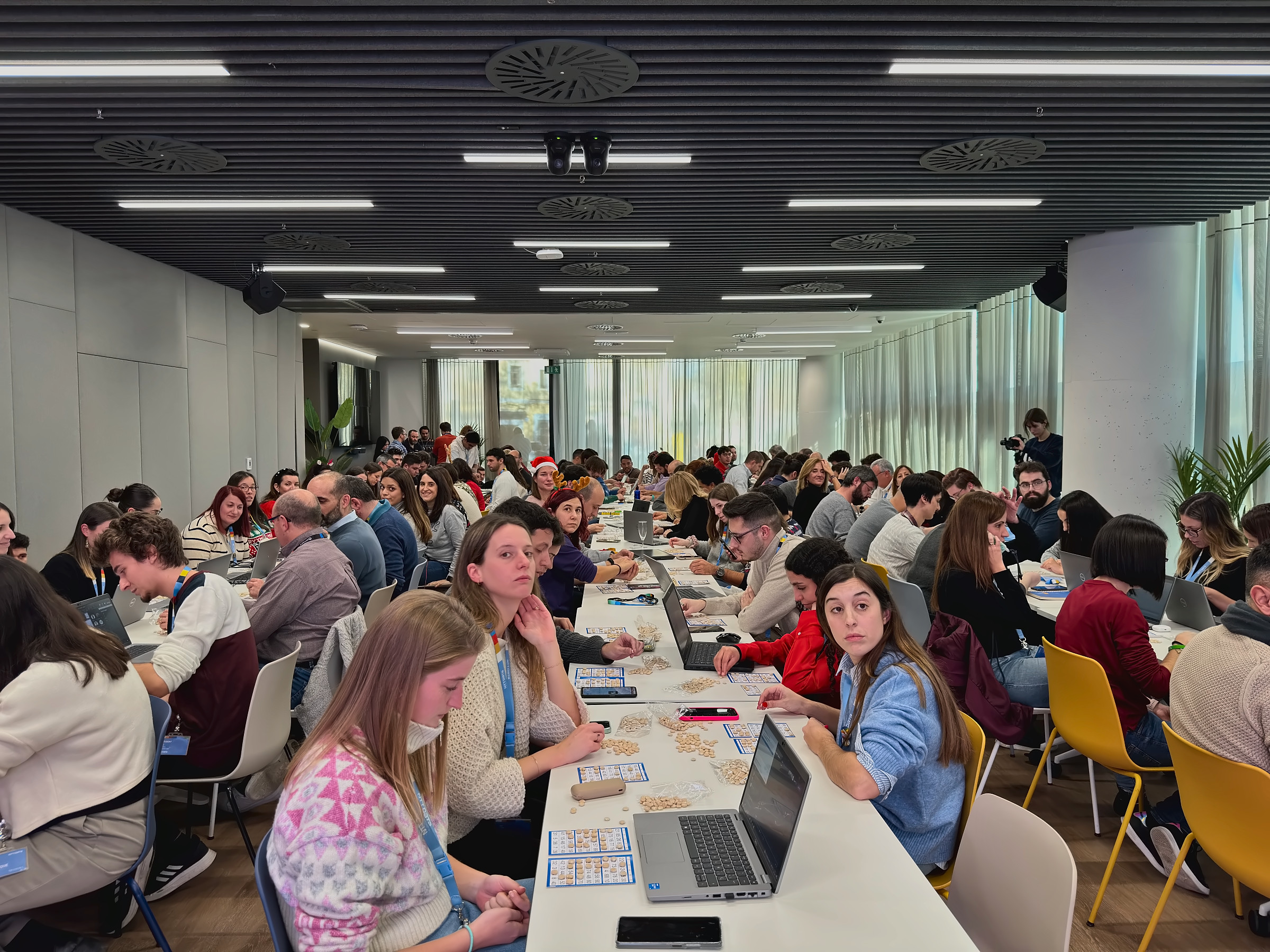 La oficina de NTT DATA jugando al Quinto de Navidad con cartones en las mesas