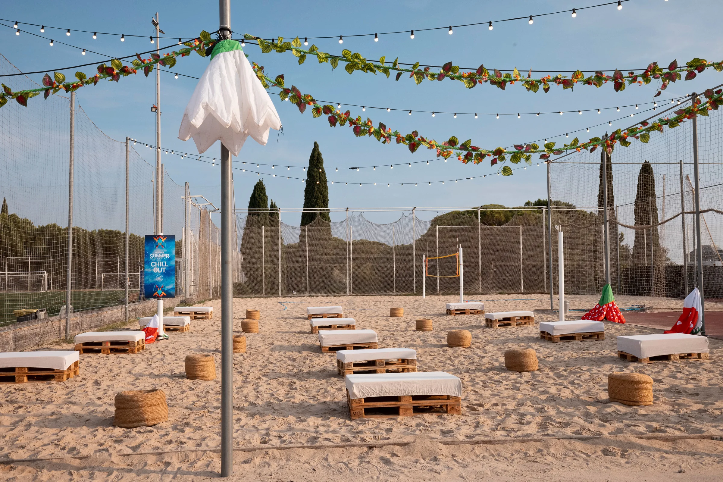 Zona de playa con arena, palés y guirnaldas en el Summer Sound de NTT DATA