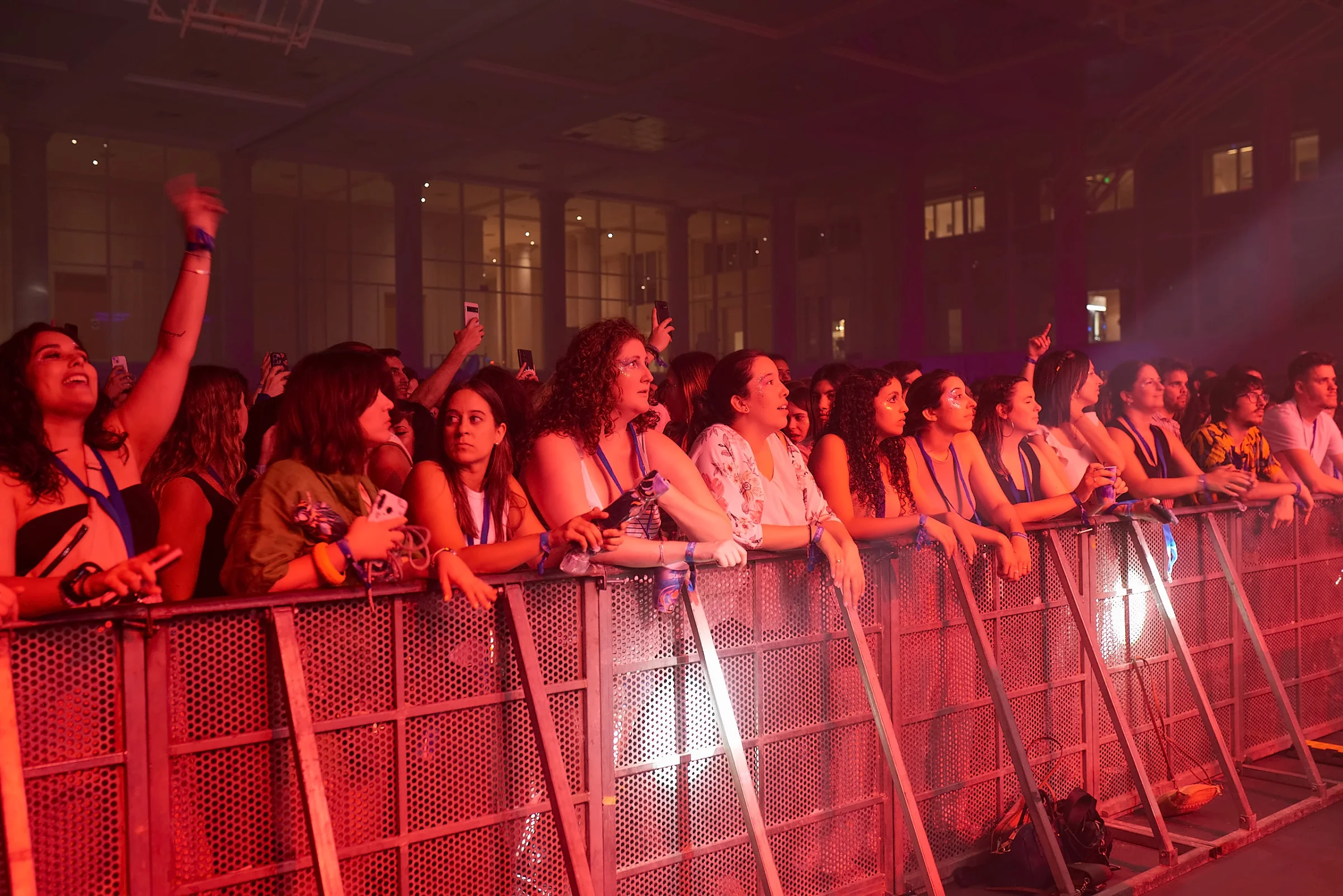Público en la valla del escenario bajo luz roja
