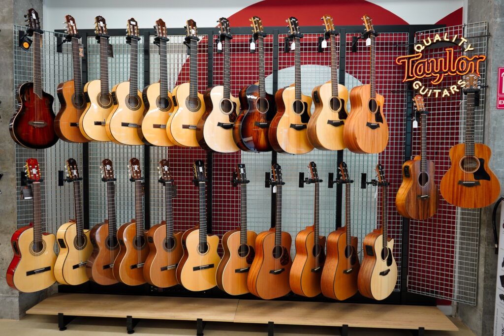 Pared de guitarras acústicas de la tienda nUme de Sevilla sobre la gráfica mural de la marca