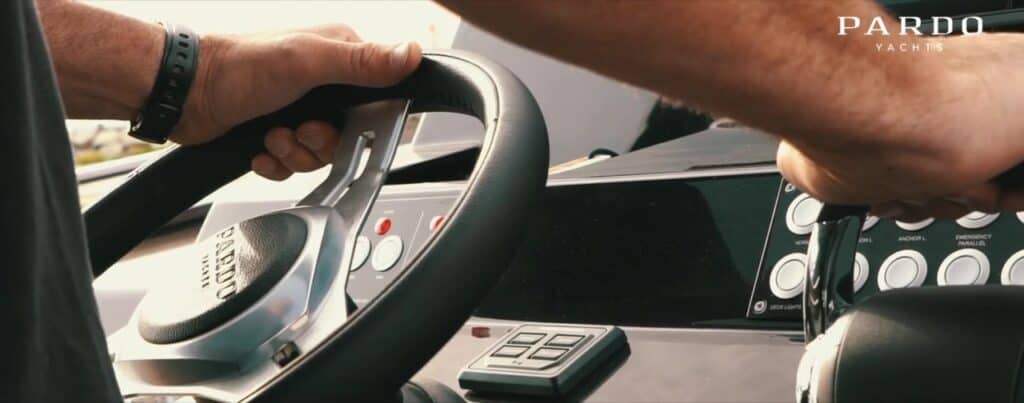 Manos al timón de una embarcación Pardo Yachts, detalle del puesto de mando