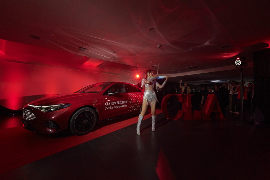 Violinista en directo junto al nuevo Mercedes-Benz CLA recién desvelado, con las letras CLA en rojo
