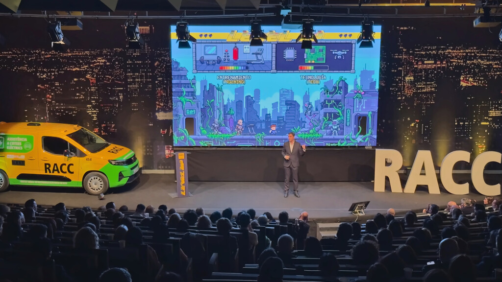 The stage at RACC’s 2026 sales meeting with a pixelated city on screen during a talk