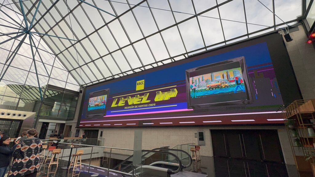 Pantalla del vestíbulo con la gráfica pixelada de Level Up en la reunión de ventas 2026 del RACC