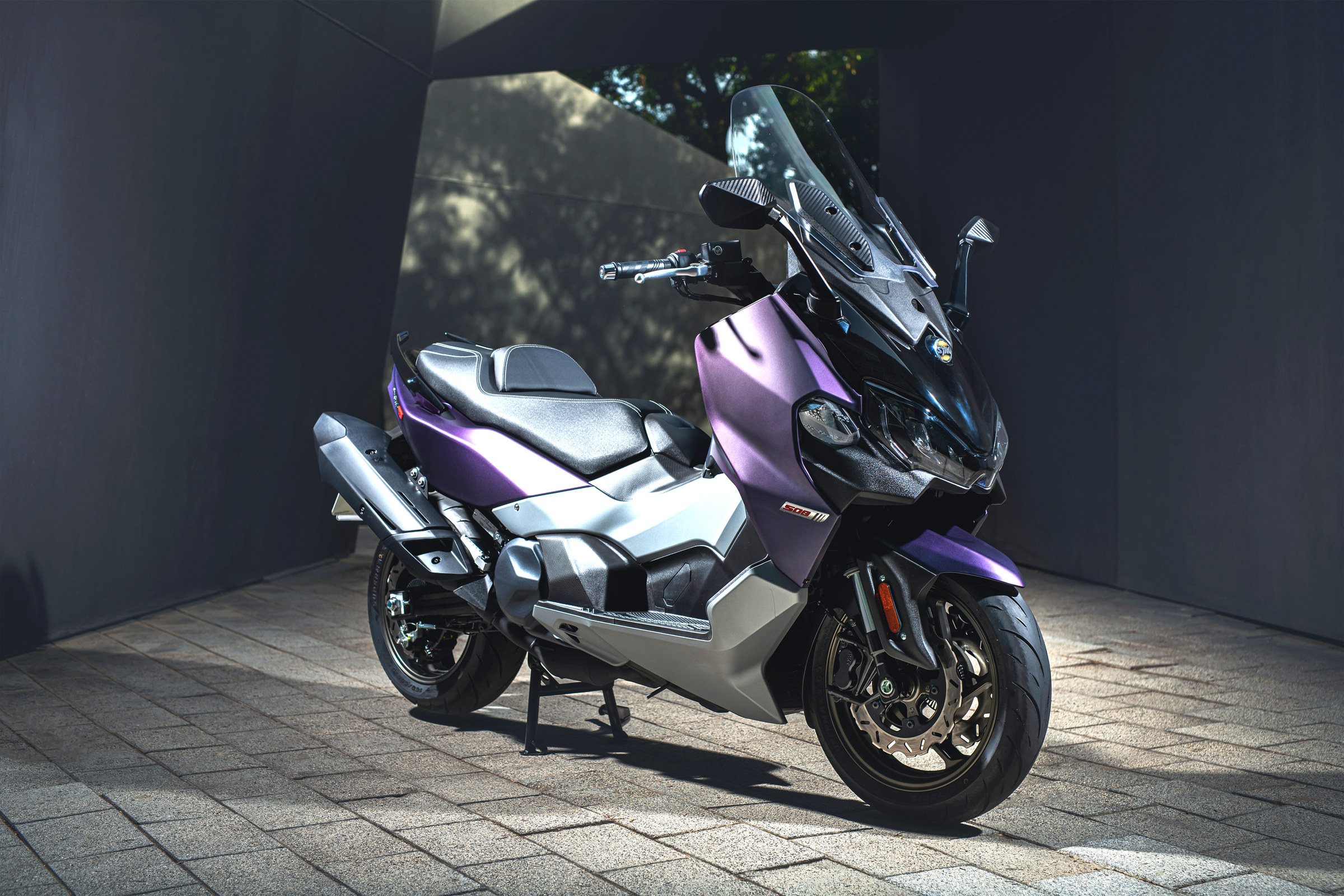 Maxsym TL 508 morado aparcado bajo una estructura de hormigón
