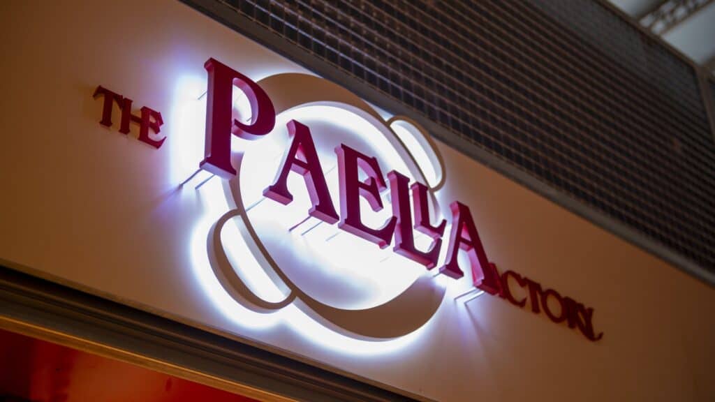 Rótulo iluminado de The Paella Factory sobre la parada