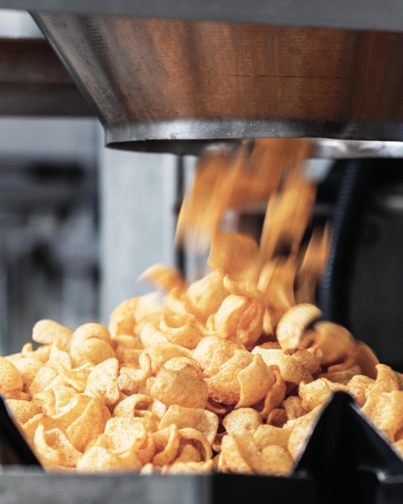 Snacks de maíz cayendo de la tolva en la línea de producción de Tutichip