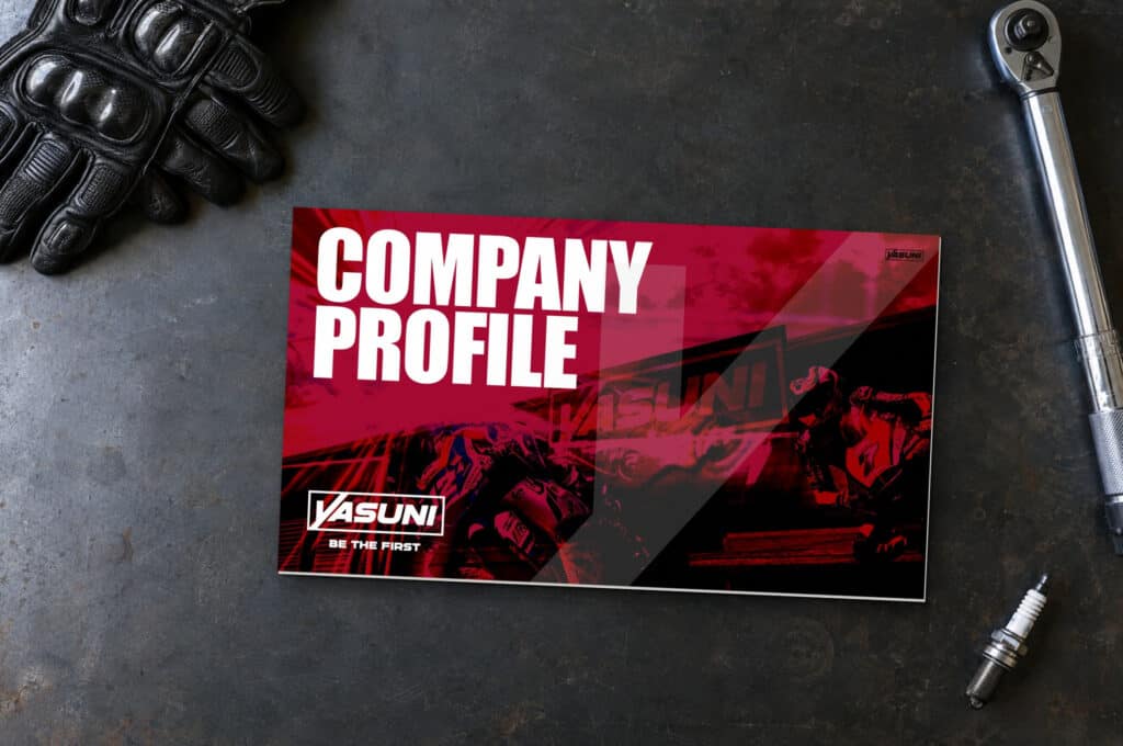 Recreación: el company profile de Yasuni impreso, sobre un banco de taller junto a unos guantes de competición