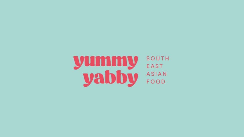 Logotipo de Yummy Yabby en rosa sobre turquesa, con el descriptor South east asian food