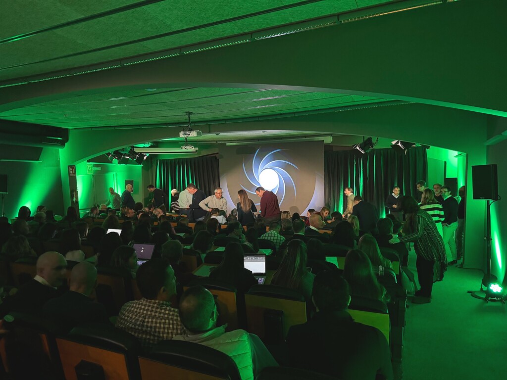The auditorium at the 2023 Adam Foods sales convention, lit in green, with the sales network in their seats