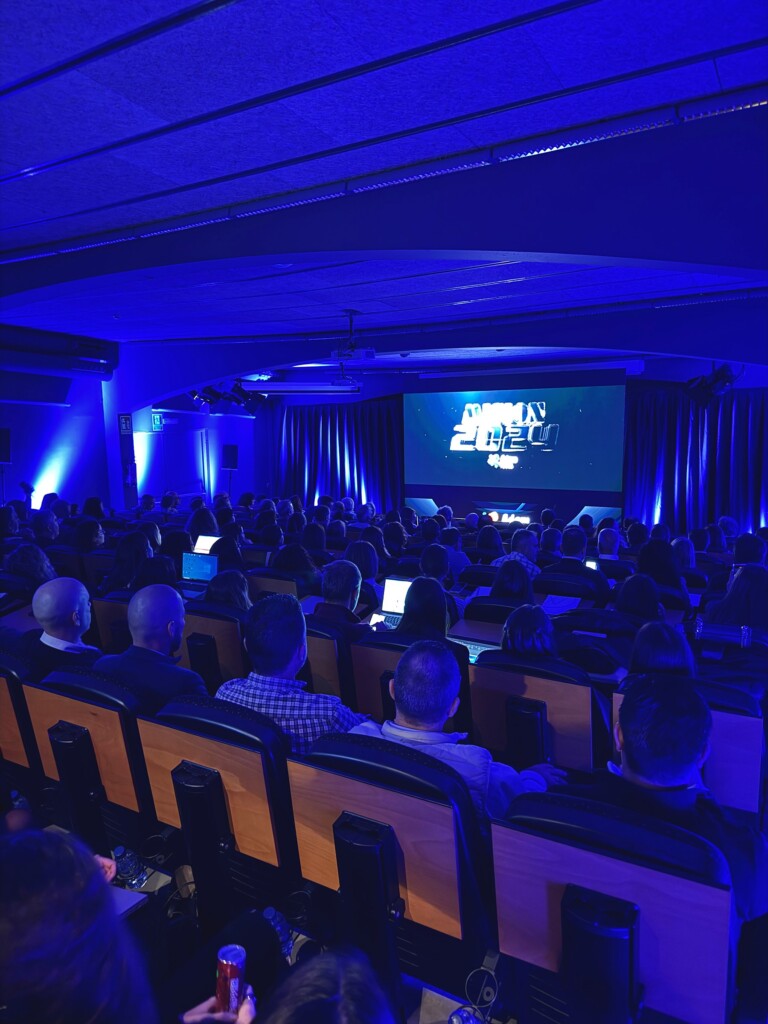 The auditorium at the 2023 Adam Foods sales convention in blue, with the event screen