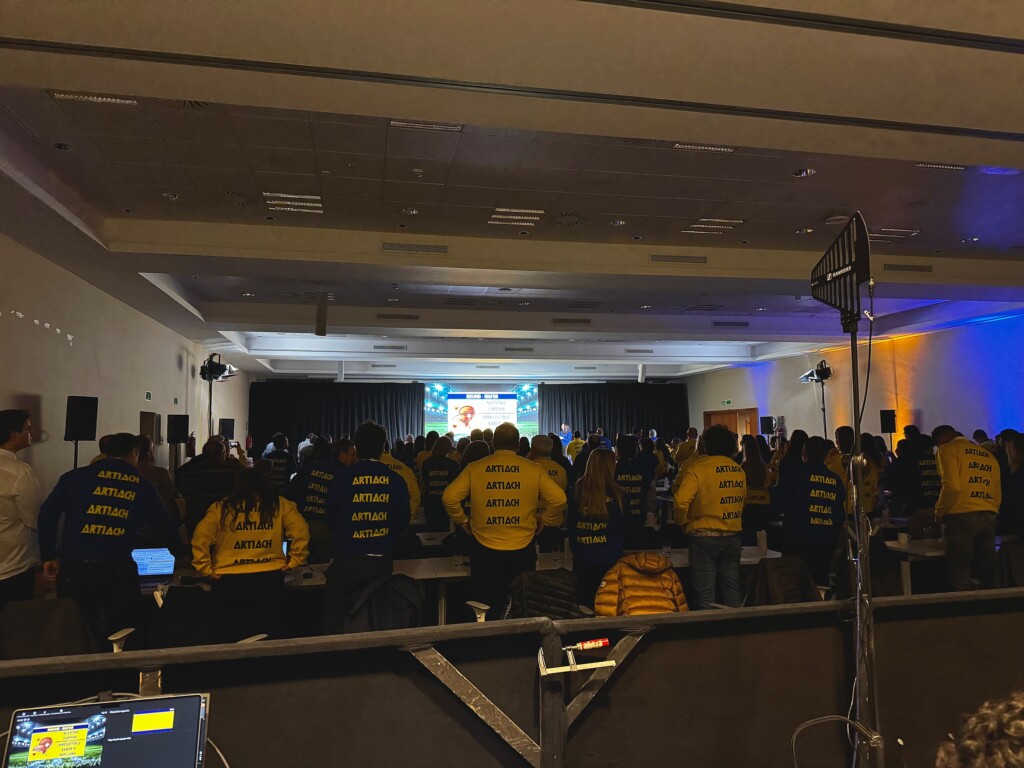 Attendees on their feet in their Artiach jackets in the room at the Adam Foods convention