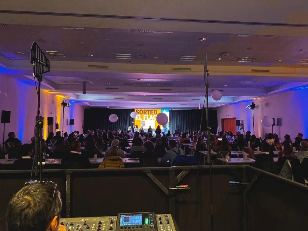 A prize draw on stage at the Adam Foods sales convention, seen from the control desk