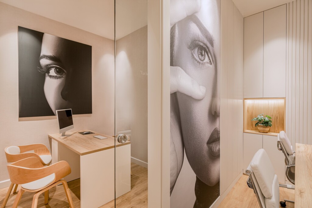 An office with a wooden desk and large-format black-and-white portraits