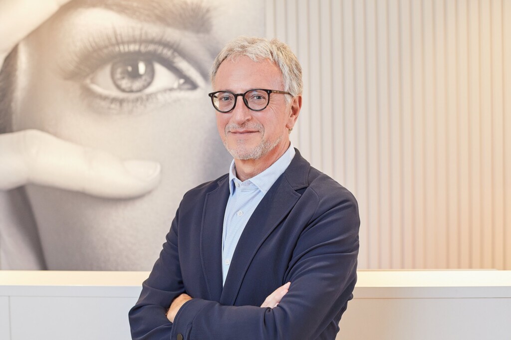 Dr Gorka, in a blue jacket, in front of the portrait of a gaze at the clinic’s reception