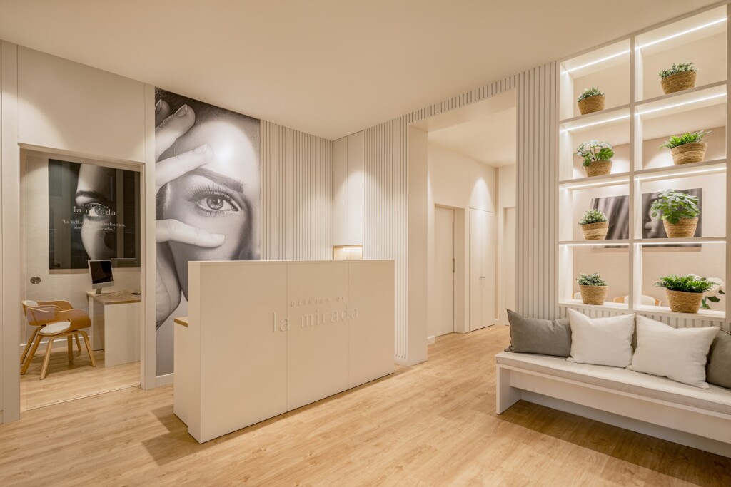 Reception and waiting area at Clínica de la Mirada, with the lit shelving and plants