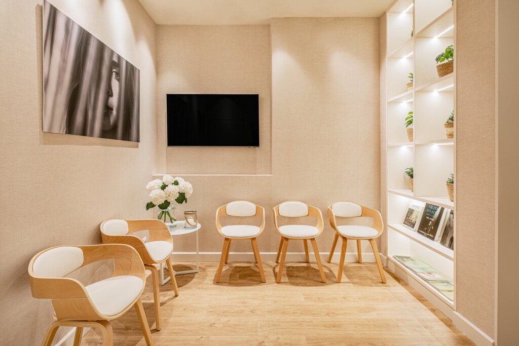 Waiting room with wooden chairs, white hydrangeas and a black-and-white portrait
