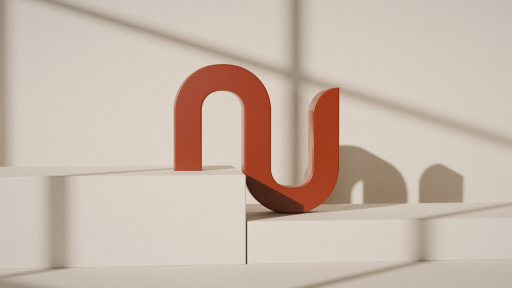 The nume symbol in three dimensions, in clay colour, on a two-level plinth in window light