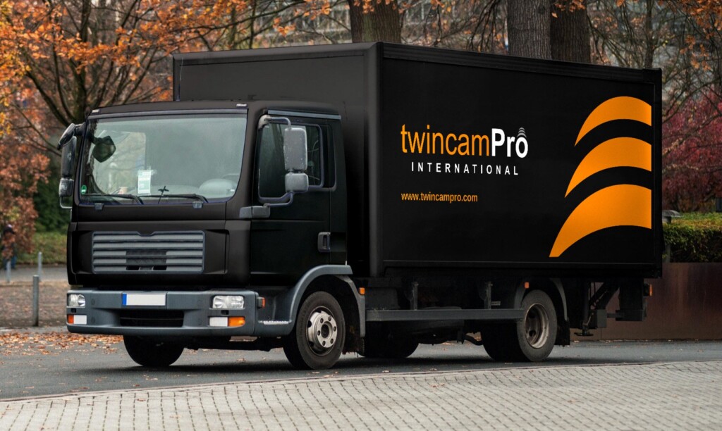 Recreación: camión rígido negro de TwincamPro con el logotipo, la web y los arcos del símbolo en naranja en la caja